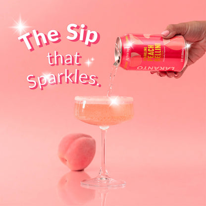 Hand pouring a can of Lakanto Peach Bellini Sparkling Mocktail into a glass with a pink background and text 'The Sip that Sparkles'.