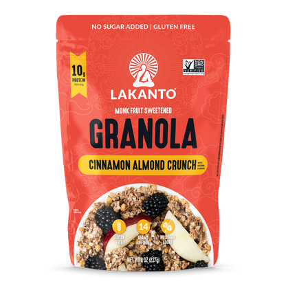 A red stand-up pouch of Lakanto Monk Fruit Sweetened Granola in Cinnamon Almond Crunch flavor, shown on a plain white background. The package features a bowl photo of granola with fruit and includes text such as 'No Sugar Added | Gluten Free' and '10g Protein Per Scoop'.