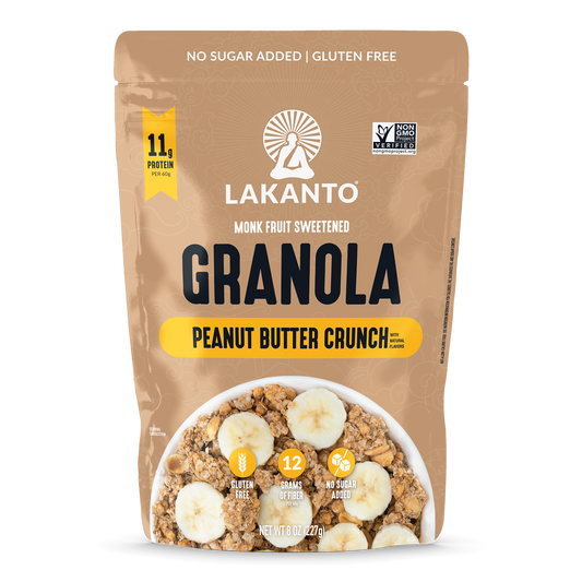 A stand-up pouch of Lakanto Monk Fruit Sweetened Granola in Peanut Butter Crunch flavor, shown on a plain white background. The packaging is tan with black and yellow text and a bowl photo of granola with banana slices on the front.